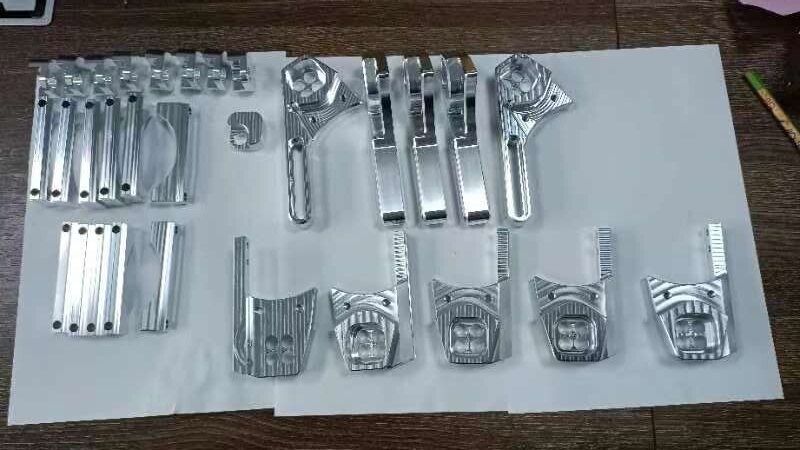 A batch of machined adapter parts laid out on paper
