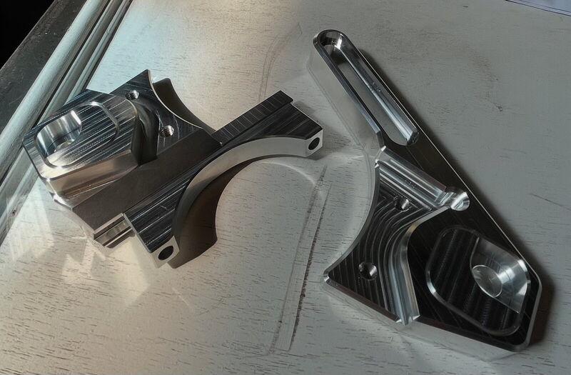 Two machined aluminum brake adapters