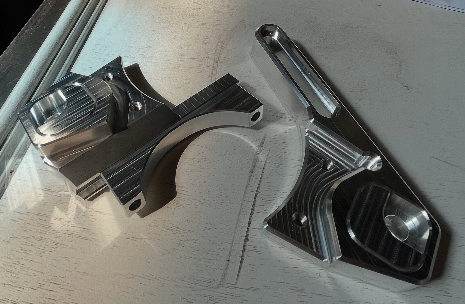 Two machined aluminum brake adapters