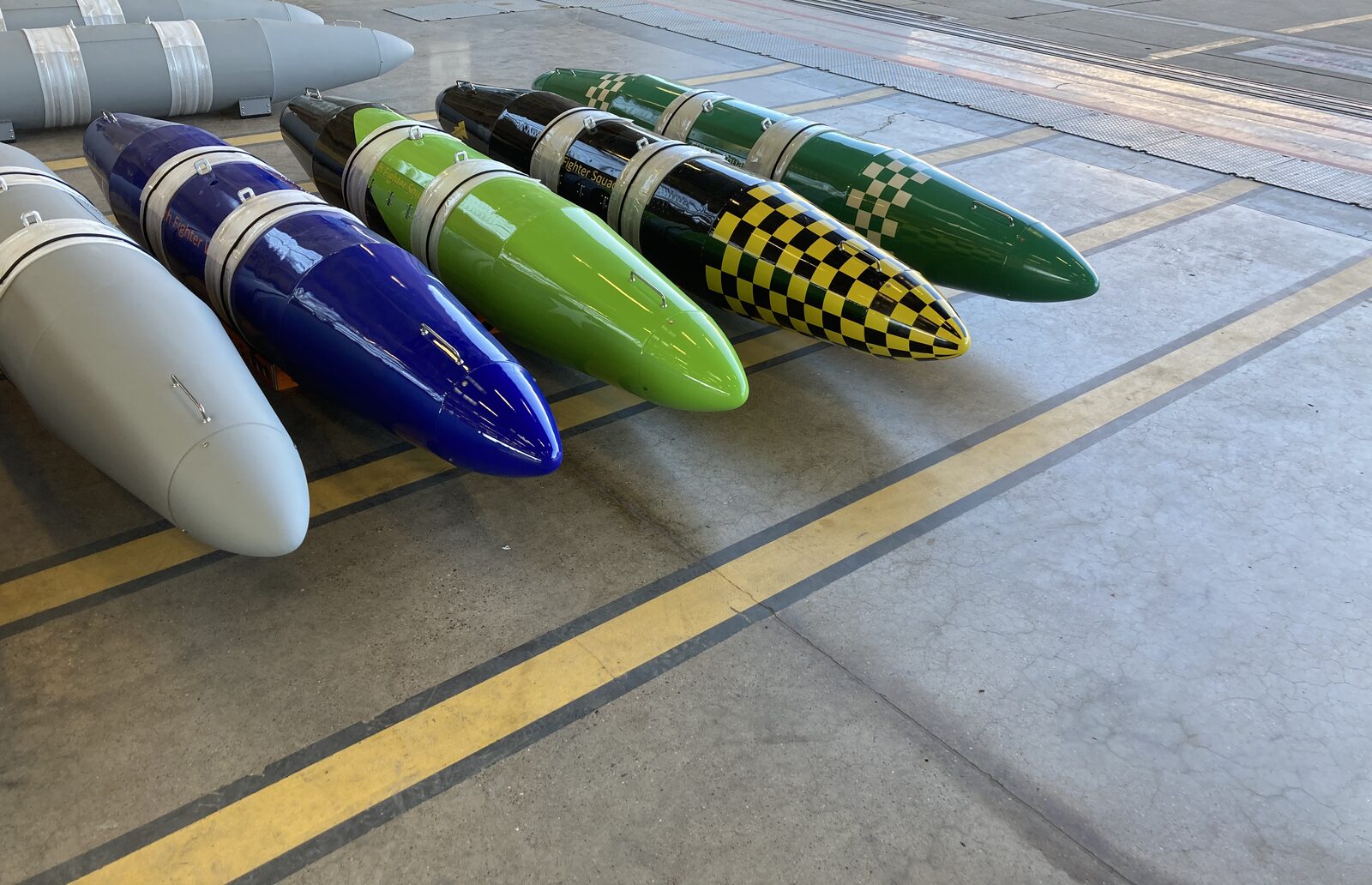 Freshly painted travel pods lined up on a hangar floor