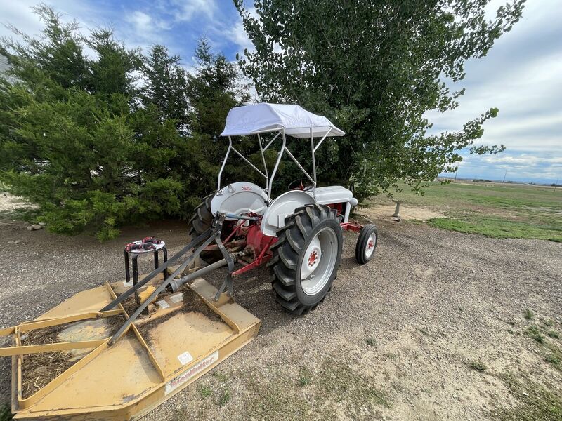 The tractor from behind, top on, with a mower attached